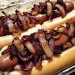 Grilled Winter BBQ Bacon Dogs wrapped in crispy bacon, topped with bourbon-glazed onions, and served on toasted buns.